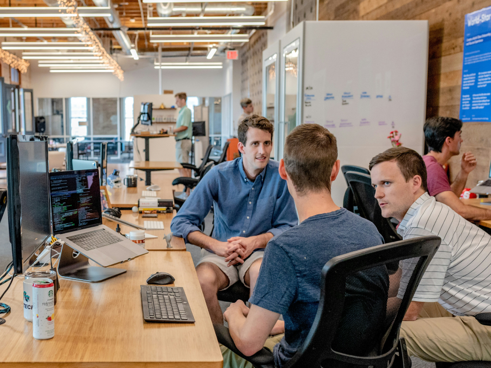 A group of young Canadian workers talking at the office, about whether or not their jobs will be replaced by AI.